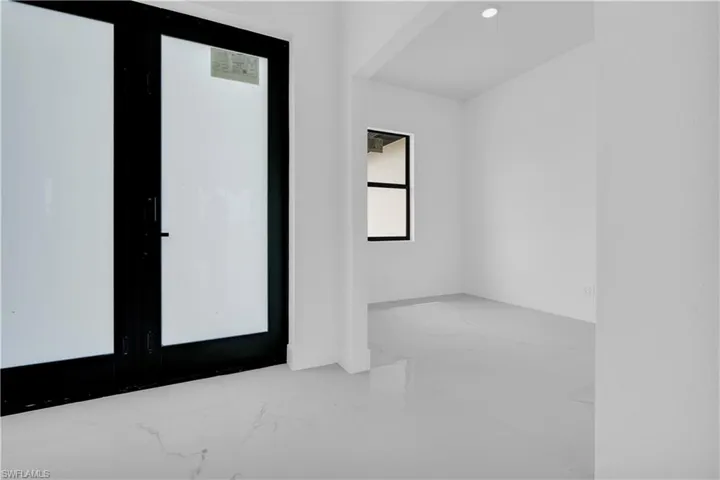 Foyer with marble finish floors, recessed lighting, and french doors
