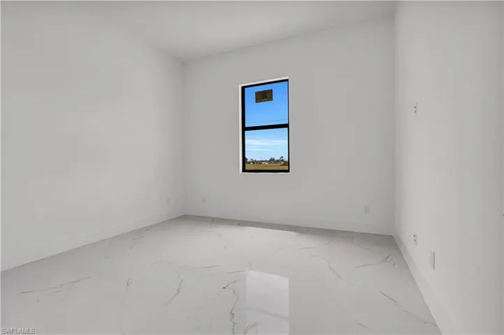 Empty room featuring light marble finish flooring and baseboards