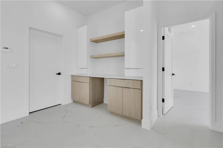 Bedroom featuring light-colored walls, a tufted headboard, and a chandelier