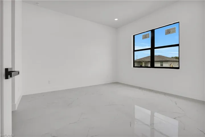 Kitchen featuring light marble finish floors, stainless steel appliances, light stone counters, modern cabinets, and hanging light fixtures
