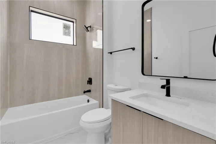 Bathroom with  shower combination, vanity, and light marble finish floors