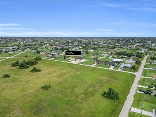 Aerial view of property and surrounding area with nearby suburban area