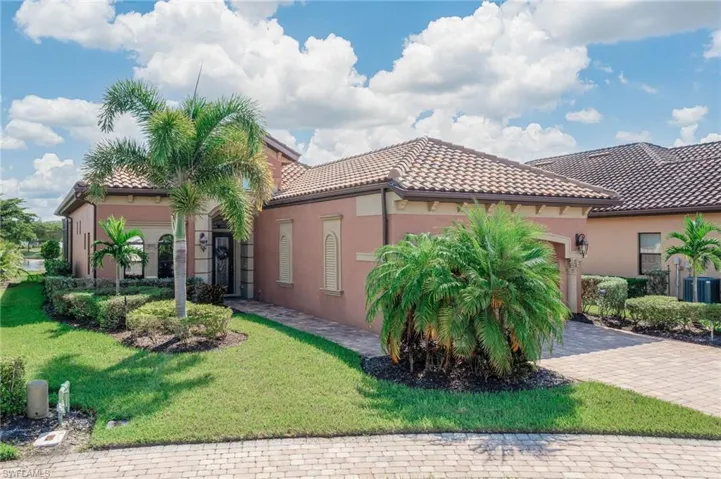 Mediterranean / spanish house featuring a front lawn and central AC unit