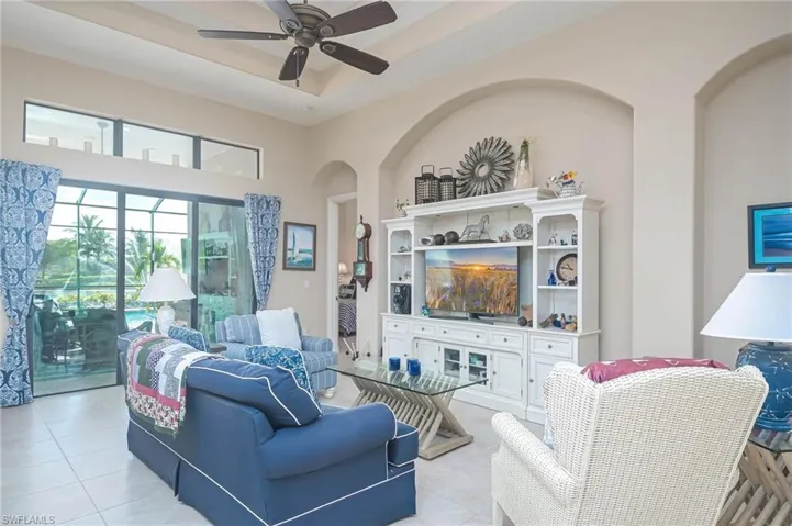 Tiled living room featuring a towering ceiling and ceiling fan