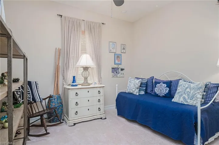 Carpeted bedroom featuring ceiling fan