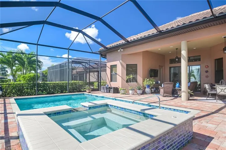 View of swimming pool with a lanai, an in ground hot tub, a patio, and ceiling fan