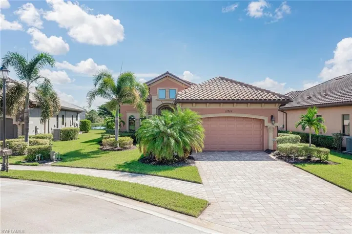 Mediterranean / spanish-style house featuring a garage, a front lawn, and central AC unit
