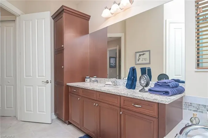 Bathroom featuring vanity, tile patterned flooring, and decorative backsplash