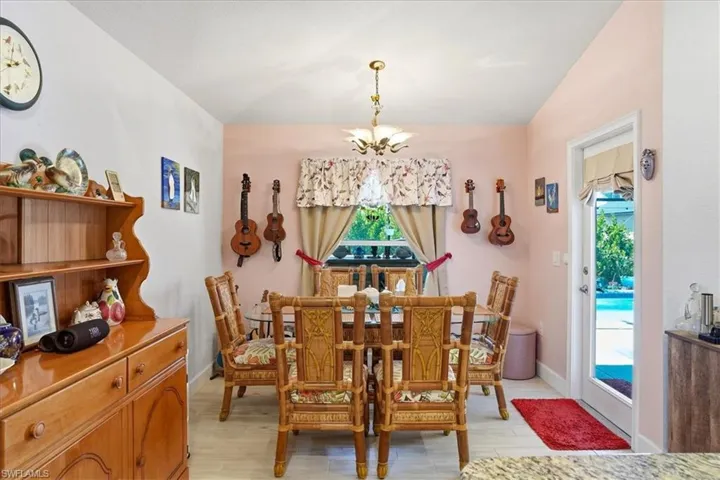 Dining area with a chandelier, vaulted ceiling, and light wood-type flooring