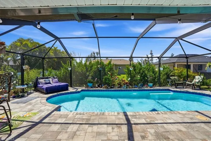 Outdoor pool featuring a sunroom, a lanai, and a patio