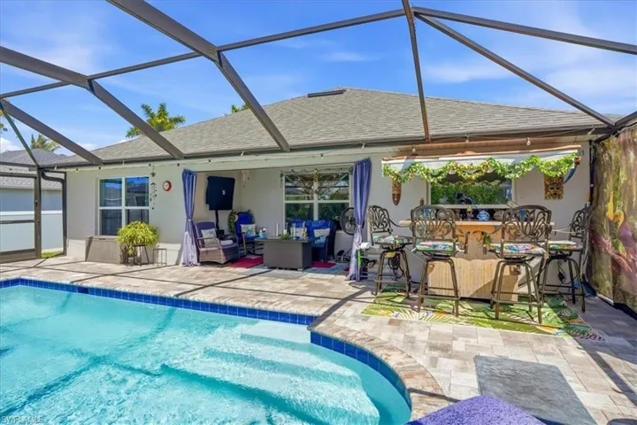 Outdoor pool featuring a sunroom, a lanai, a patio area, and outdoor lounge area