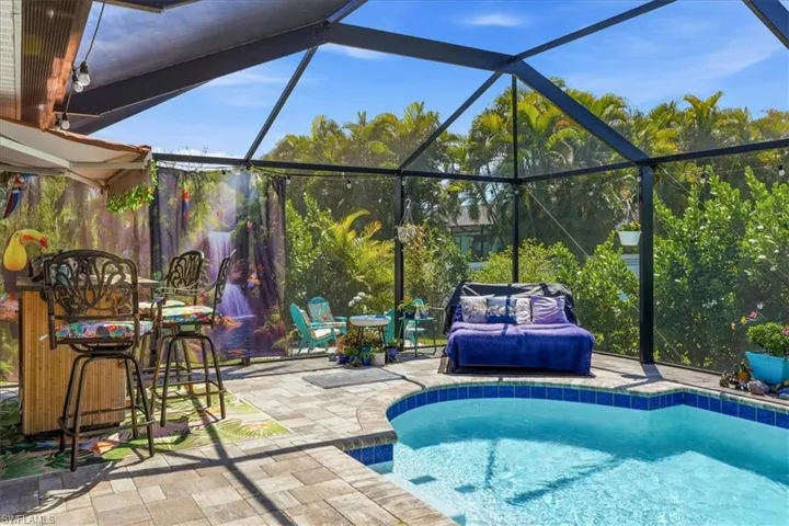 Outdoor pool featuring a lanai and a sunroom