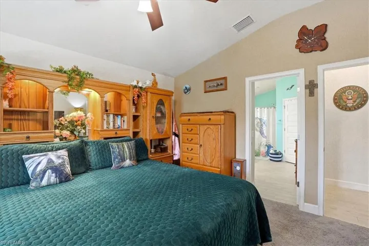Carpeted bedroom with lofted ceiling and a ceiling fan