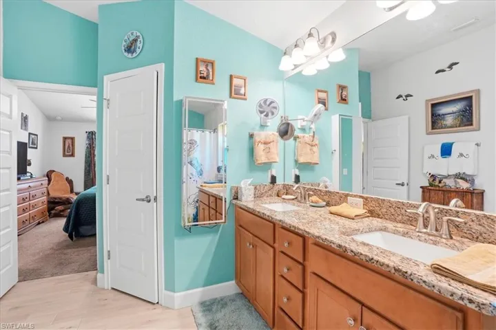 Ensuite bathroom featuring double vanity and light wood-type flooring
