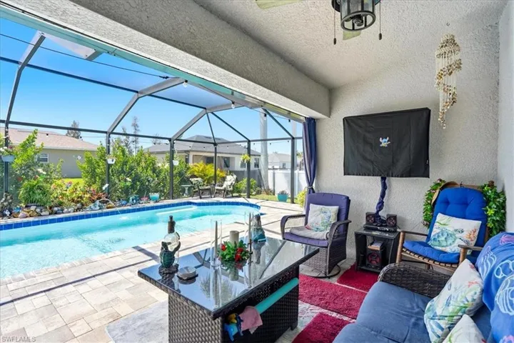Outdoor pool featuring a sunroom, a patio, glass enclosure, and an outdoor lounge area