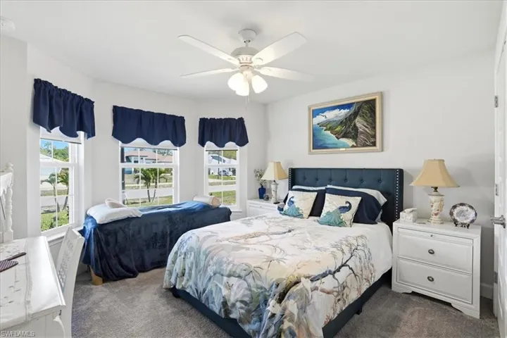 Carpeted bedroom featuring a ceiling fan