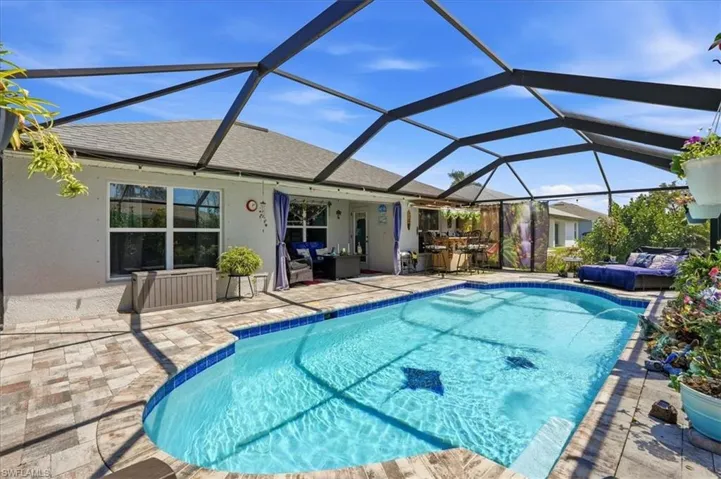 Swimming pool featuring a sunroom, a patio, and glass enclosure