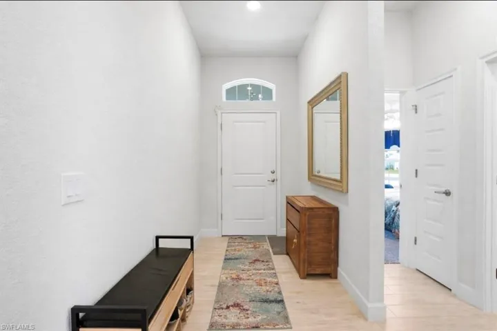 VIRTUALLY STAGED Foyer featuring light wood finished floors and baseboards