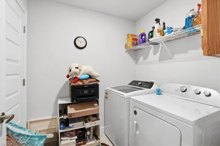 Laundry area featuring separate washer and dryer and baseboards