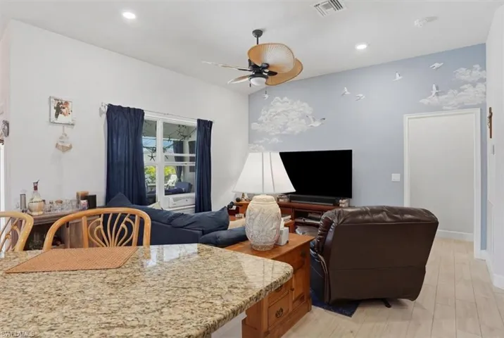 Living area with ceiling fan, light wood-style flooring, and recessed lighting