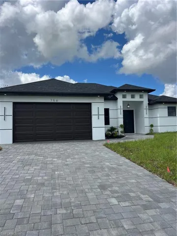 Prairie-style house featuring decorative driveway, stucco siding, and a garage