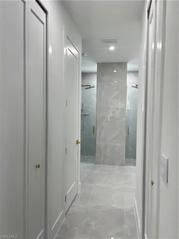 Hall featuring marble finish floors