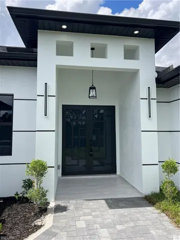 Entrance to property featuring stucco siding and french doors