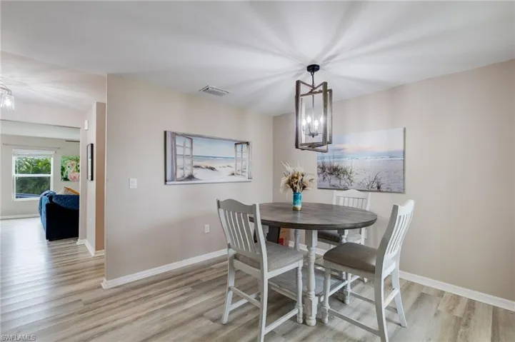 Dining area with light vinyl flooring and a chandelier