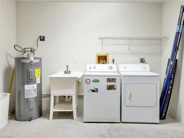 Washroom featuring washing machine and dryer and water heater