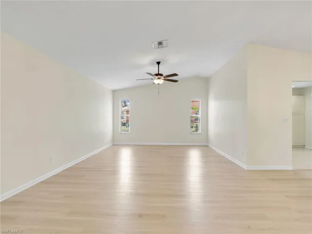 Spare room featuring ceiling fan, light hardwood / wood-style flooring, and vaulted ceiling