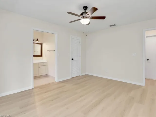 Unfurnished bedroom featuring light hardwood / wood-style flooring, a closet, ensuite bath, and ceiling fan
