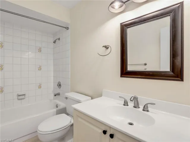 Full bathroom featuring vanity, tiled shower / bath, and toilet