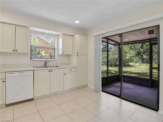 Kitchen with white cabinetry, dishwasher, a healthy amount of sunlight, and light tile patterned flooring