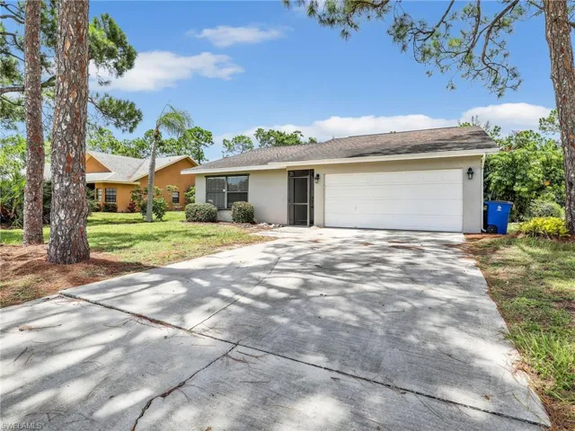 Single story home with a garage and a front yard