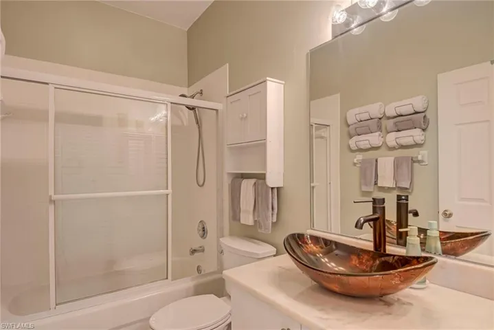 Full bathroom with vanity and enclosed tub / shower combo