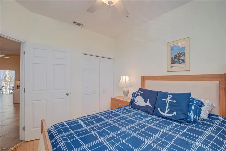 Bedroom with ceiling fan, a closet, and wood finished floors