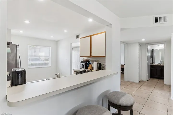 Kitchen featuring light tile patterned floors, freestanding refrigerator, light countertops, visible vents, and recessed lighting