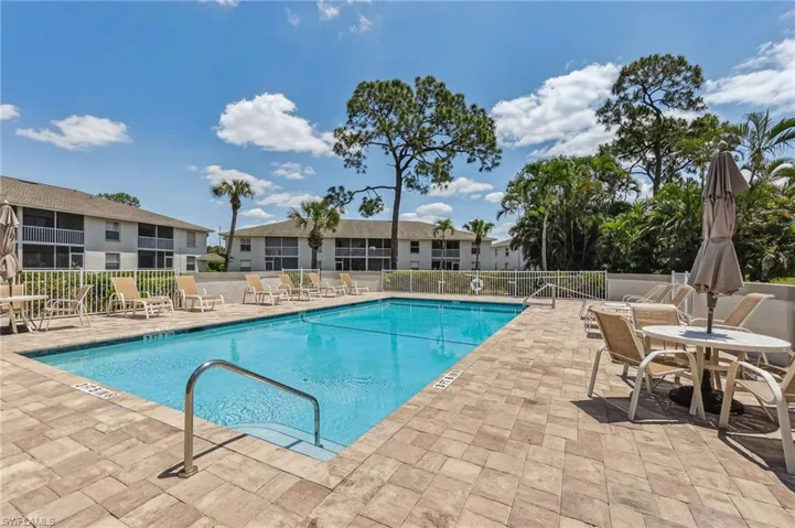 Community pool featuring fence and a patio