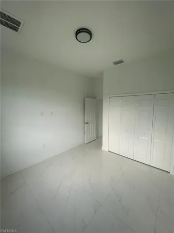 Unfurnished bedroom featuring a closet and light tile patterned floors