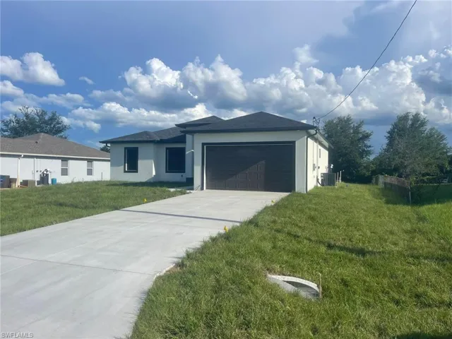 View of front of property featuring a garage and a front yard