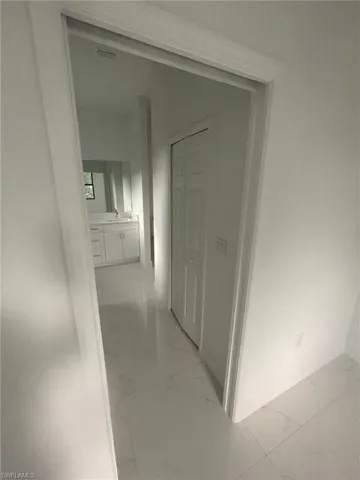 Corridor with sink and light tile patterned floors