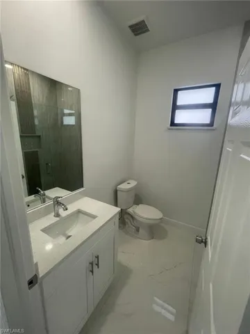 Bathroom featuring tile patterned flooring, toilet, and vanity