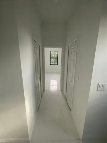 Corridor with light tile patterned flooring
