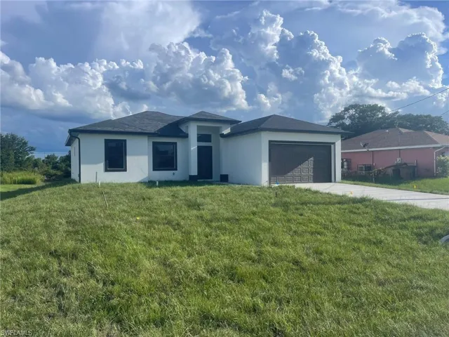 View of front of property with a garage and a front yard