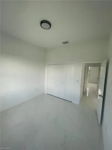 Unfurnished bedroom featuring light tile patterned flooring and a closet