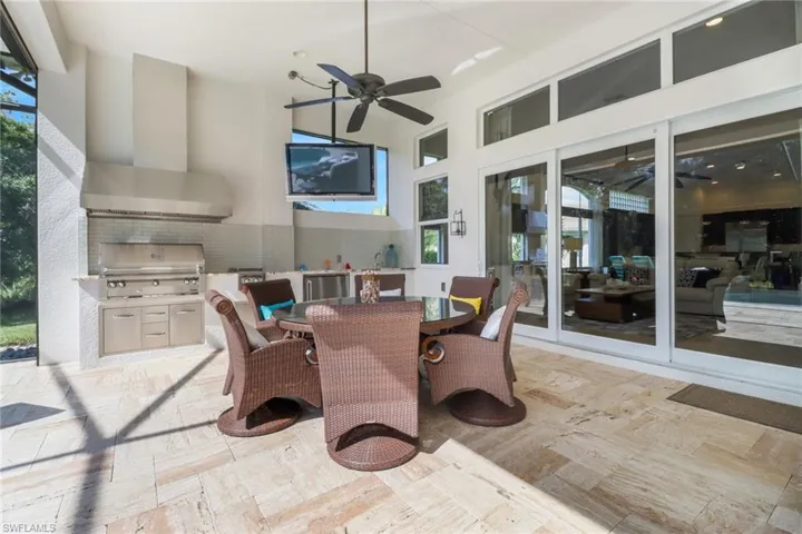 View of patio with area for grilling, ceiling fan, grilling area, and french doors