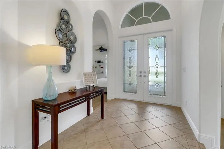 Tiled entrance foyer featuring french doors and ceiling fan