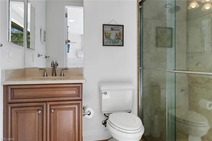 Bathroom with vanity, toilet, and an enclosed shower