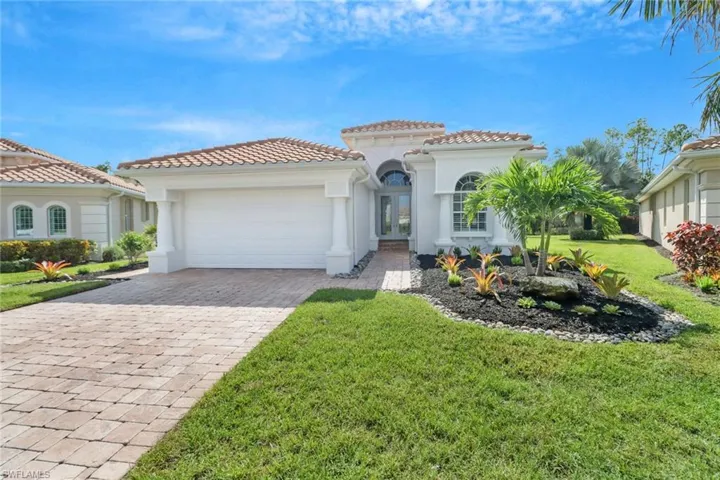Mediterranean / spanish home with a front yard and a garage