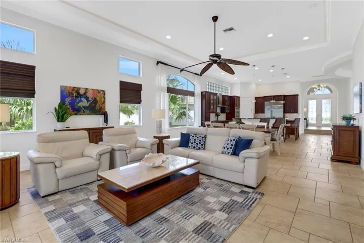 Living room featuring ornamental molding, light tile patterned floors, and ceiling fan